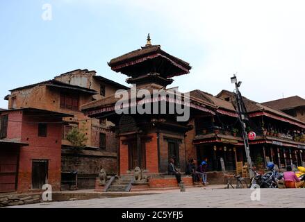 Menschen, die um einen Tempel auf dem Durbar-Platz in Bhaktapur, Nepal, sitzen Stockfoto