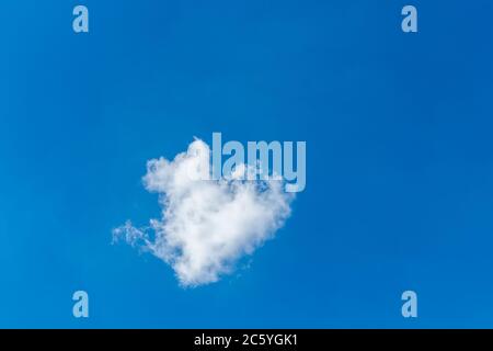 Romantische einsame Wolke in Form eines Herzens auf einem blauen Himmel. Liebeskonzept. Stockfoto