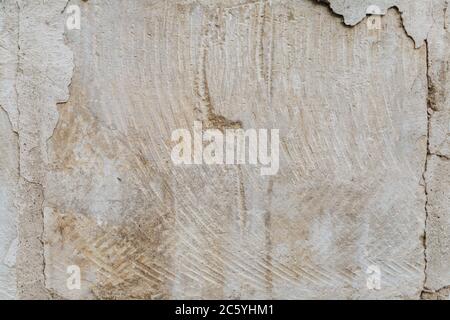 Der Putz blättert von der Ziegelwand. Die Gründung eines Wohnhauses bricht allmählich zusammen. Stockfoto