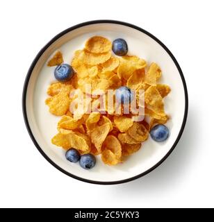 Schüssel mit Cornflakes und Milch mit Heidelbeeren isoliert auf weißem Hintergrund, Draufsicht dekoriert Stockfoto