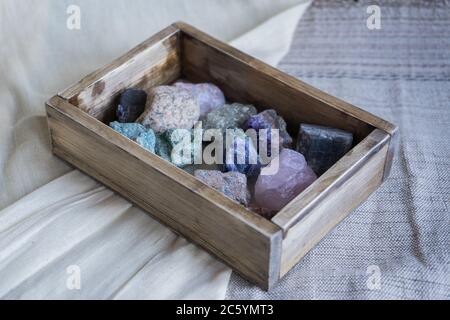 Bunte Edelsteine in einer Holzkiste. Edelsteine. Sammlung von Mineralien Stockfoto