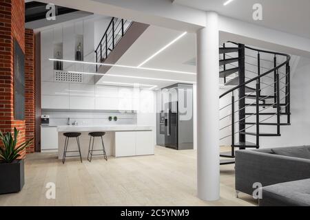 Moderne Loft-Wohnung mit Zwischengeschoss, Backsteinmauern und Küche offen zum Wohnzimmer Stockfoto