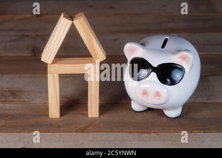 Aufstieg auf dem Immobilienmarkt. Sparschwein und Haus Stockfoto