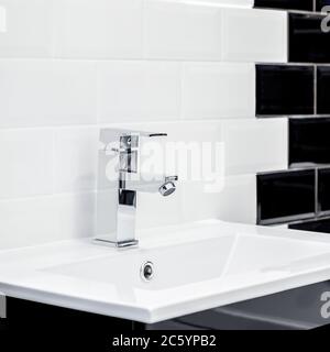 Kleines Waschbecken im Badezimmer und moderne Ziegelsteine in schwarz und weiß Stockfoto
