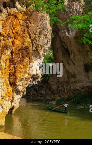 Der Höhleneingang des Dorfes Bamei, ein verstecktes Dorf in den Bergen der Provinz Yunnan, mit einem Boot nach innen und außen. Stockfoto