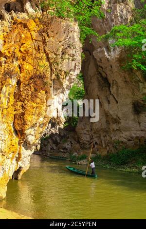Der Höhleneingang des Dorfes Bamei, ein verstecktes Dorf in den Bergen der Provinz Yunnan, mit einem Boot nach innen und außen. Stockfoto