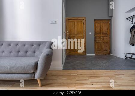 Apartment mit modernen, grau Sofa und alten, hölzernen Türen Stockfoto