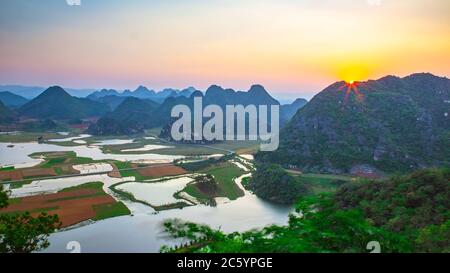 Puzhehei, typische Karstlandschaft in der Provinz Yunnan, bei Sonnenuntergang. Stockfoto