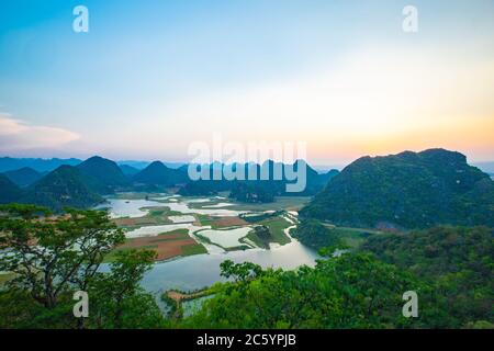 Puzhehei, typische Karstlandschaft in der Provinz Yunnan, bei Sonnenuntergang. Stockfoto