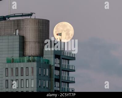 Cork City, Cork, Irland. Juli 2020. Ein Vollmond fällt hinter dem irischen Tricolor herab, das über das Elysian, Irlands zweithöchstes Gebäude in Cork City, Irland, flybt. - Credit; David Creedon / Alamy Live News Stockfoto