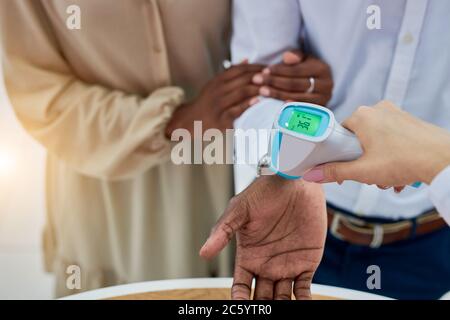 Junge afrikanische verheiratete Paar ist auf Temperatur in Händler überprüft, Arzt Frau verwenden spezielle Vorrichtung, Nahaufnahme Foto der Hände Stockfoto