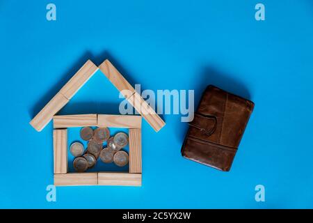 Nahaufnahme des Holzmodells und der Schlüssel mit Taschenrechner auf blauem Hintergrund. Hypothek Immobilien Versicherung kaufen Traum Haus Shopping Verkauf Miete Konzept. Wohnung lag Stockfoto