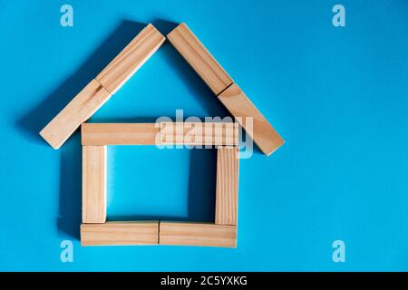 Holzhaus auf blauem Hintergrund. Kreditvergabe an die Öffentlichkeit. Das Konzept der erschwinglichen Wohnraum und Hypotheken, um ein Haus zu kaufen. Stockfoto