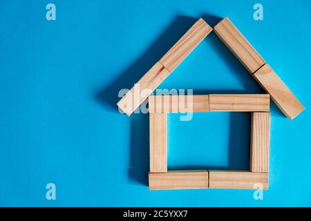 Holzhaus auf blauem Hintergrund. Kreditvergabe an die Öffentlichkeit. Das Konzept der erschwinglichen Wohnraum und Hypotheken, um ein Haus zu kaufen. Stockfoto