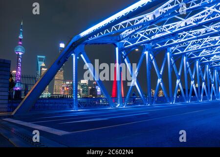 Nachtansicht der Waibaidu Bridge, einer der Wahrzeichen von Shanghai, mit Verkehr und modernen Wolkenkratzern im Hintergrund. Stockfoto