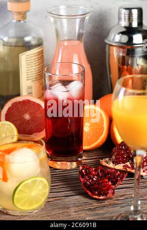 Gin Cocktail Granatapfel auf einem Tisch zwischen Zitrusfrüchten und Getränken. Stockfoto