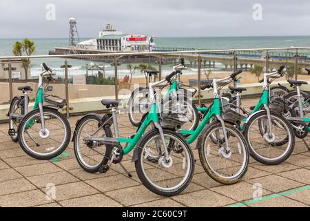 Beryl-Bikes mit Bournemouth Pier in der Ferne in Bournemouth, Dorset UK an einem grauen Nieseltag im Juli Stockfoto