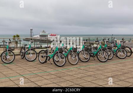 Beryl-Bikes mit Bournemouth Pier in der Ferne in Bournemouth, Dorset UK an einem grauen Nieseltag im Juli Stockfoto