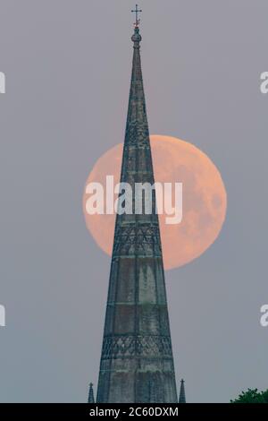 Salisbury, Wiltshire, Großbritannien. Mai 2020. Der Flower Supermoon hängt tief am frühen Morgenhimmel über der Salisbury Cathedral, die ihre 800 feiert Stockfoto