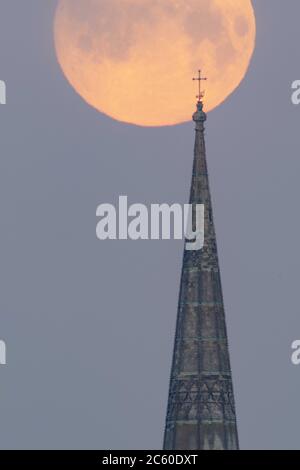 Salisbury, Wiltshire, Großbritannien. Mai 2020. Der Flower Supermoon hängt tief am frühen Morgenhimmel über der Salisbury Cathedral, die ihre 800 feiert Stockfoto