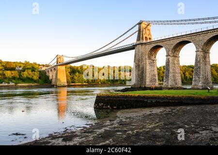 Die Menai Suspension Bridge (1826), entworfen von Thomas Telford, verbindet das Festland von Wales mit der Insel Anglesey. Menai Bridge, Wales, Großbritannien. Stockfoto