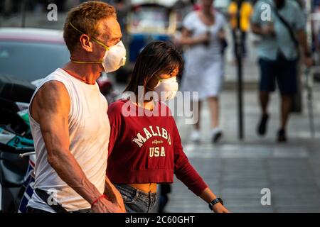 Paar, die während der Pandemie 19 in Bangkok, Thailand, mit Gesichtsmaske auf der Straße spazieren Stockfoto