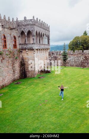 Junge Touristin läuft auf Gras auf der Burg Soutomaior in Galicien, Spanien Stockfoto