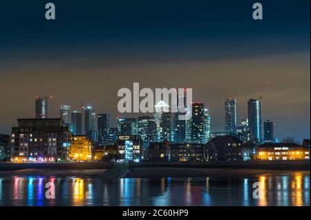 Blick auf Canary Wharf bei Nacht über die Themse, London, England. Stockfoto