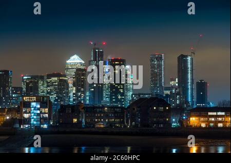 Blick auf Canary Wharf bei Nacht über die Themse, London, England. Stockfoto