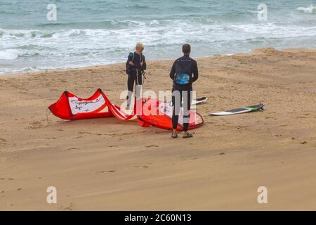 Kitesurfer bereiten sich auf Kitesurfen in Bournemouth, Dorset UK an windigen Nieseltag im Juli - Kitesurfer Kitesurfer Kitesurfer Stockfoto