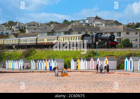 Goodrington Sands, Paignton, Devon, Großbritannien. Juli 2020. Die Dartmouth Dampfeisenbahn wird wieder eröffnet, mit dem ersten Personenzug des Tages bei seiner Wiedereröffnung, der von 7827 Lydham Manor hinter den Strandhütten von Goodrington Sands auf seiner Rückreise von Kingswear zum Bahnhof von Paignton in Devon nach der weiteren Lockerung der Coronavirus-Sperrregeln gezogen wird Erlaubt die Heritage Line, Passagiere wieder zu transportieren. Bildquelle: Graham Hunt/Alamy Live News Stockfoto