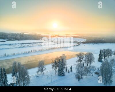 Luftaufnahme des Pielisjoki Flusses im Winter auf dem Hintergrund des Sonnenuntergangs, Joensuu, Finnland. Stockfoto