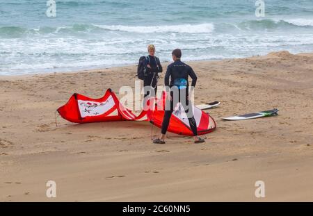 Kitesurfer bereiten sich auf Kitesurfen in Bournemouth, Dorset UK an windigen Nieseltag im Juli - Kitesurfer Kitesurfer Kitesurfer Stockfoto