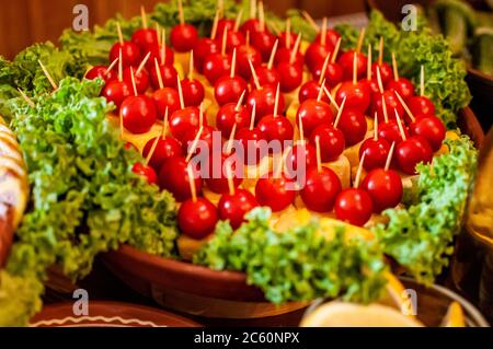 canape mit Käse und Kirschtomaten, verziert mit Salatblättern Stockfoto