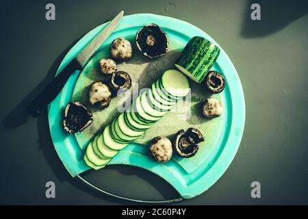 Nahaufnahme des Schneidebretts mit gehackten Zucchini-Pilzen und einem Messer Stockfoto