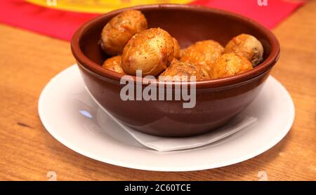 Klassische Kanarische Tapa - Papas arrugadas, faltige Kartoffeln mit roter Mojo-Sauce Stockfoto