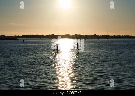 Europa Niederlande - zwei Männer auf einem Stand-up-Paddleboard bei Sonnenuntergang auf den Kananen der Niederlande Stockfoto