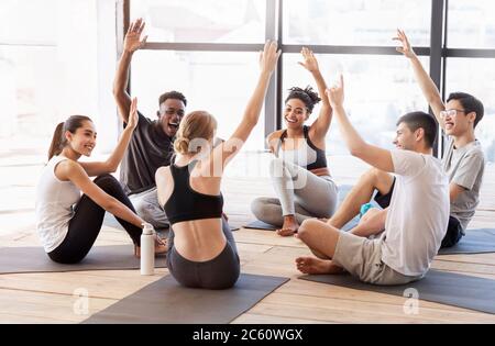 Motivierte Multirassische Freunde Voting Mit Erhobenen Händen Nach Dem Training Im Yoga Studio Stockfoto