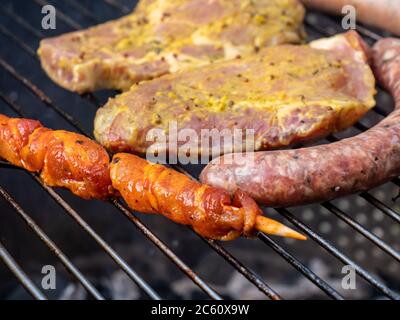 Grillbrenner mit Steak und Wurst auf dem Grill Stockfoto