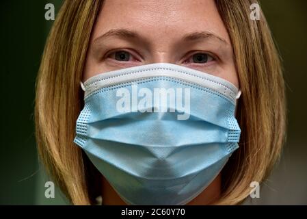 FRSM oder Fluid Surgical Mask wird von einem NHS-Mitarbeiter im Kampf gegen Covid-19 modelliert. Eine dreilagige Maske oder OP-Maske, die richtige Art zu tragen. Stockfoto