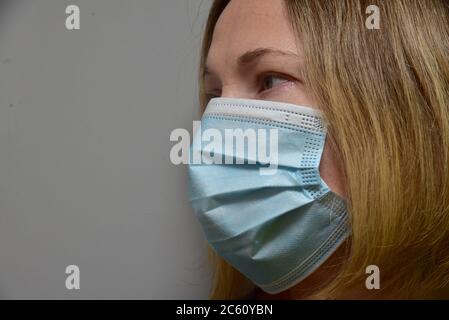 FRSM oder Fluid Surgical Mask wird von einem NHS-Mitarbeiter im Kampf gegen Covid-19 modelliert. Eine dreilagige Maske oder OP-Maske, die richtige Art zu tragen. Stockfoto