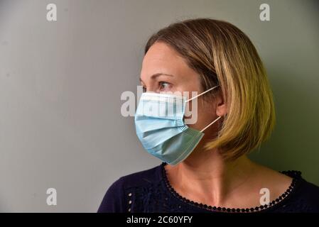 FRSM oder Fluid Surgical Mask wird von einem NHS-Mitarbeiter im Kampf gegen Covid-19 modelliert. Eine dreilagige Maske oder OP-Maske, die richtige Art zu tragen. Stockfoto