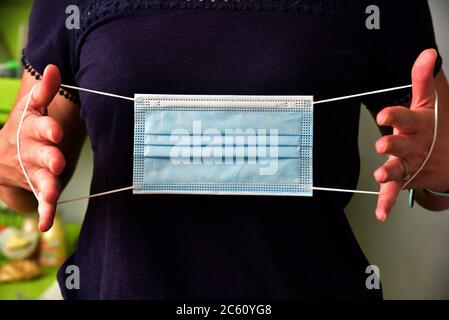 FRSM oder Fluid Surgical Mask wird von einem NHS-Mitarbeiter im Kampf gegen Covid-19 modelliert. Eine dreilagige Maske oder OP-Maske, die richtige Art zu tragen. Stockfoto