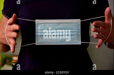 FRSM oder Fluid Surgical Mask wird von einem NHS-Mitarbeiter im Kampf gegen Covid-19 modelliert. Eine dreilagige Maske oder OP-Maske, die richtige Art zu tragen. Stockfoto