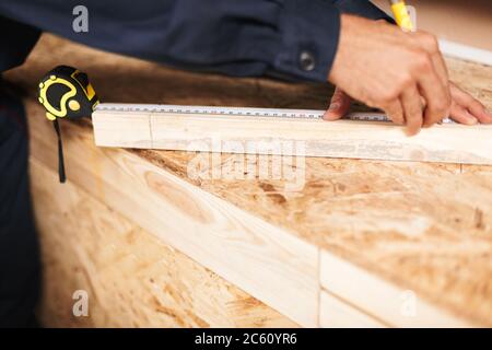 Nahaufnahme Vorarbeiter Hände mit Maßband und Bleistift in worksh Stockfoto