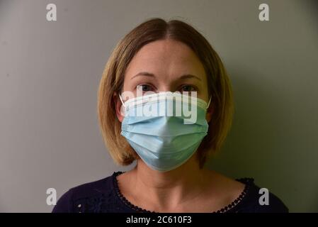 FRSM oder Fluid Surgical Mask wird von einem NHS-Mitarbeiter im Kampf gegen Covid-19 modelliert. Eine dreilagige Maske oder OP-Maske, die richtige Art zu tragen. Stockfoto