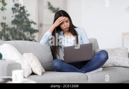 Stress für Freiberufler. Besorgt asiatische Mädchen müde nach der Arbeit auf Laptop zu Hause Stockfoto