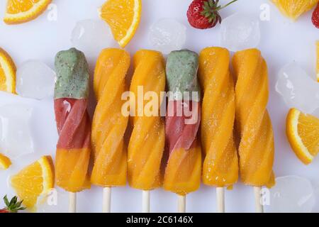 Orange Sorbet mit Eis, Scheiben von Orange und Erdbeeren auf weißem Hintergrund. Draufsicht flach Lay Sommer Konzept Stockfoto
