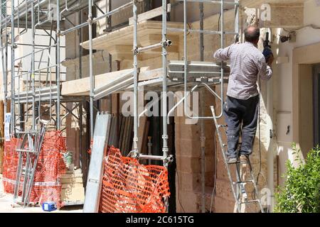 POLIGNANO A MARE, ITALIEN - 29. MAI 2017: Hausrenovierungsarbeiter arbeitet in der Altstadt von Polignano a Mare in Apulien, Italien. Stockfoto