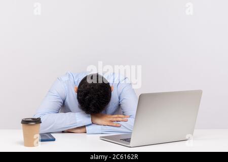 Verärgert müde Mann, Büroangestellte auf Tisch liegen, am Arbeitsplatz schlafen, dösen erschöpft gelangweilt, beschlossen, Schläfchen während Überstunden Nachtschicht zu nehmen. ich Stockfoto